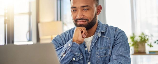 A male student looking at a laptop