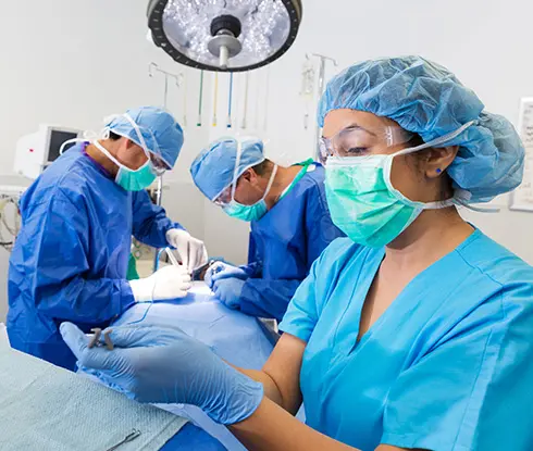 a women wearing scrubs getting tools ready for surgery